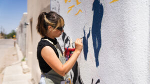 A muralist at work on the Doña Ana mural